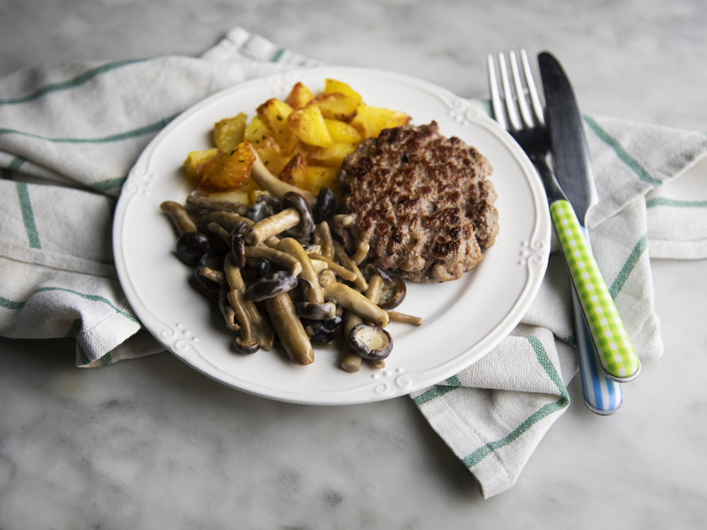 Hamburger al piatto con sugo di funghi e patate al forno